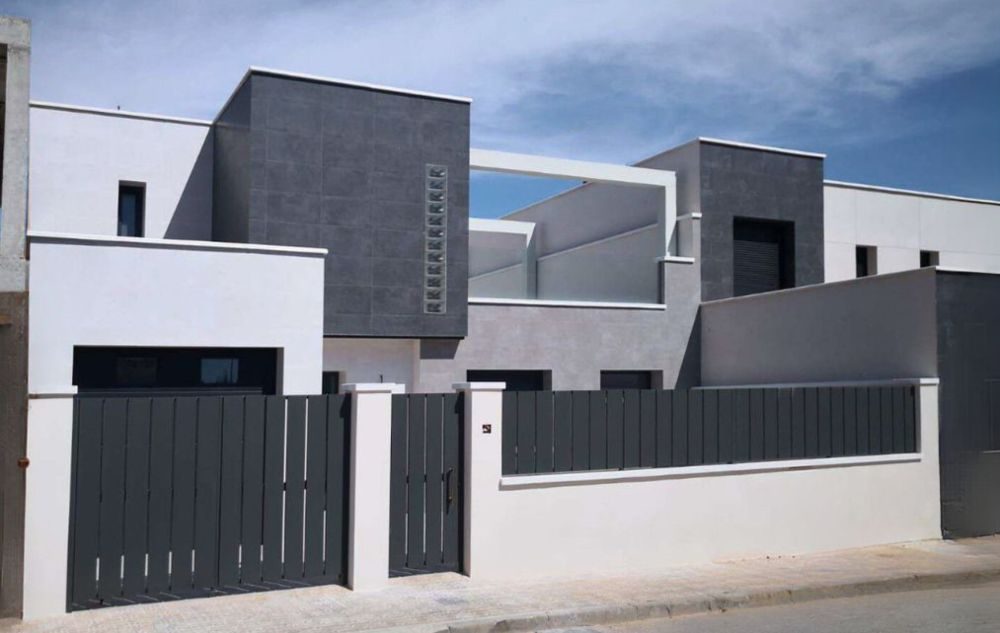 Fachada de vivienda moderna de dos plantas en colores grises, negros y blancos